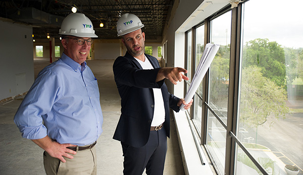 Moshe Popack holding plans pointing